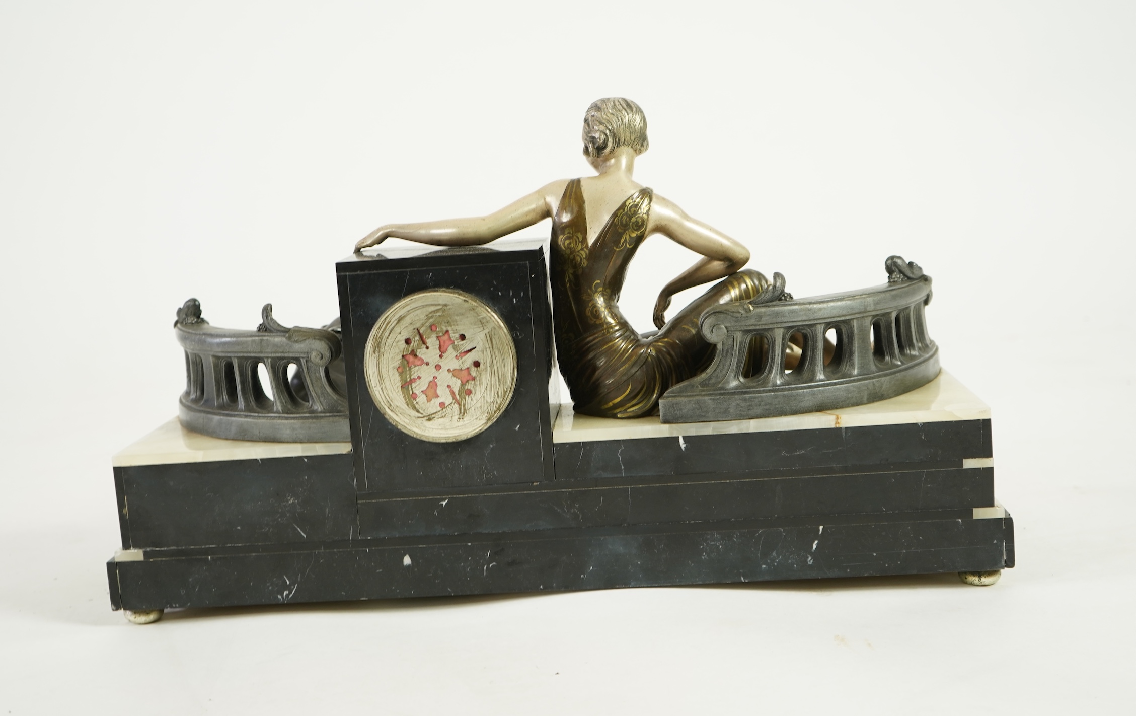 A French Art Deco onyx and patinated spelter clock surmounted with a lady and a black panther on a staircase